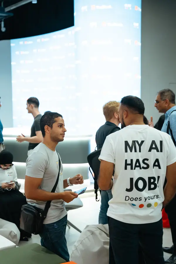 Attendees talking after a CLRT workshop, one wearing the My AI Has A Job shirt.
